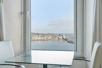a window with a table and a view of the water at Golden Hind in St Ives