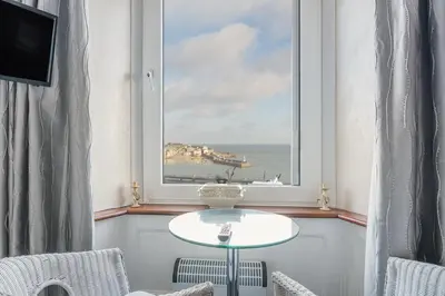 a window with a table and a view of the ocean at Golden Hind in St Ives