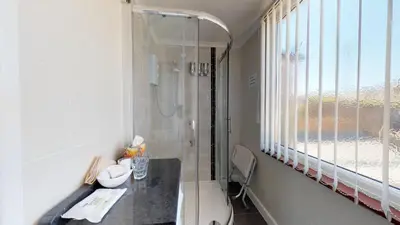 a bathroom with a shower and a glass window at Golden Hind in St Ives