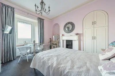 a bedroom with a bed and a desk and a window at Golden Hind in St Ives