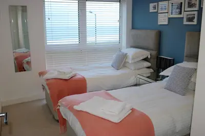 a room with two beds and a window at 19 Ocean Gate in Newquay