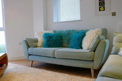 a blue couch with blue pillows in a living room at 19 Ocean Gate in Newquay