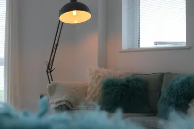 a living room with a couch and a lamp at 19 Ocean Gate in Newquay