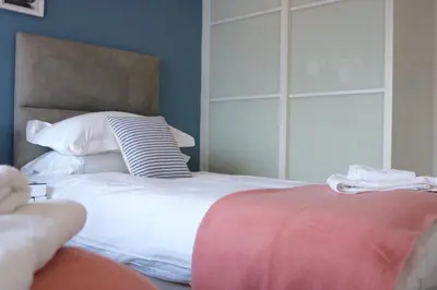a bedroom with a white bed with a headboard at 19 Ocean Gate in Newquay