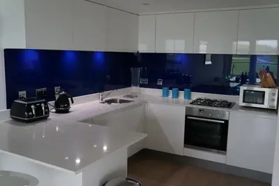 a white kitchen with a sink and a microwave at 19 Ocean Gate in Newquay