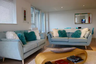 a living room with two couches and a table at 19 Ocean Gate in Newquay