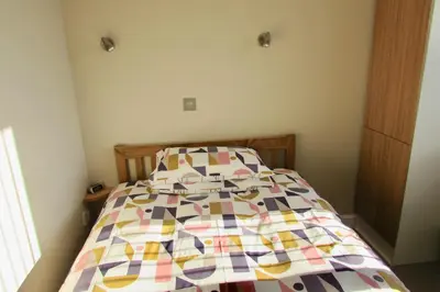 a bedroom with a bed with a colorful quilt at Westward B&B in Newquay