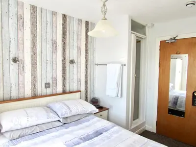 a bedroom with a bed and a mirror at Westward B&B in Newquay
