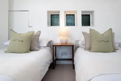 two beds in a room with two windows at Stylish Two Bedroom Cottage - In Town Centre in St Ives