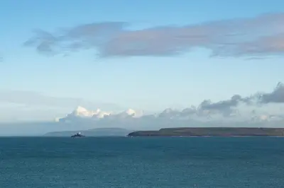 a large body of water with a ship in the distance at Stylish Two Bedroom Cottage - In Town Centre in St Ives