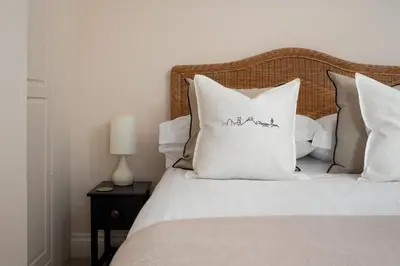 a bedroom with a bed with white sheets and pillows at Stylish Two Bedroom Cottage - In Town Centre in St Ives