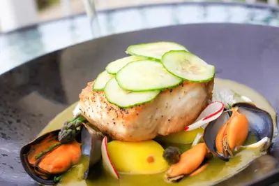 a plate with a piece of meat with cucumbers and vegetables at Driftwood Spars in St. Agnes