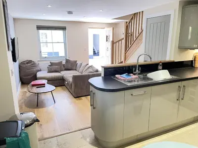 a kitchen and a living room with a couch at Harrys Hideout in St Ives
