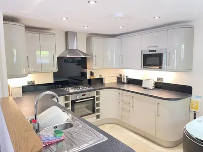 a kitchen with white cabinets and a sink at Harrys Hideout in St Ives