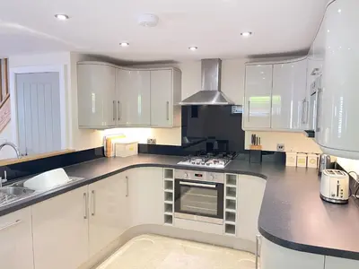a kitchen with white cabinets and a stove top oven at Harrys Hideout in St Ives