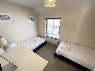 a room with two beds and a table and a window at Harrys Hideout in St Ives