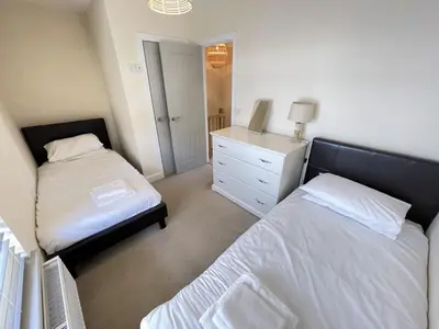 a bedroom with two beds and a dresser in it at Harrys Hideout in St Ives