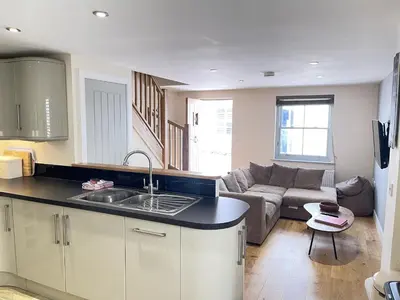 a kitchen and a living room with a couch at Rosies Retreat in St Ives