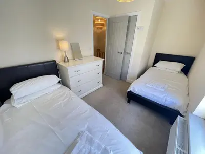 a bedroom with two beds and a white dresser at Rosies Retreat in St Ives