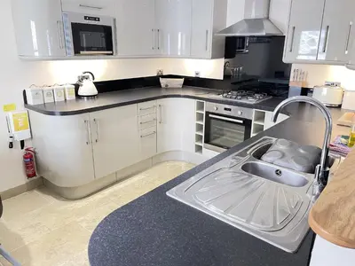 a kitchen with white cabinets and a sink at Rosies Retreat in St Ives