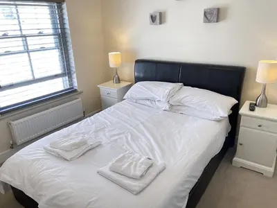 a bed with white sheets and white towels on it at Rosies Retreat in St Ives