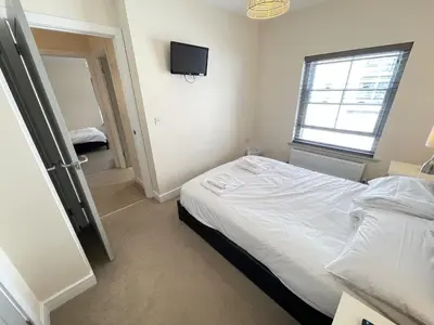 a bedroom with a bed and a television on the wall at Rosies Retreat in St Ives