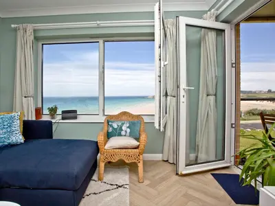 a living room with a couch and a view of the ocean at Apartment 8 in Newquay