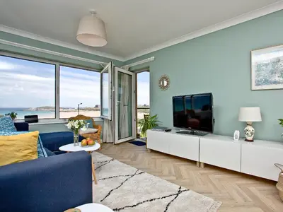 a living room with a blue couch and a tv at Apartment 8 in Newquay