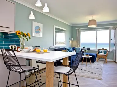 a kitchen and living room with a table and chairs at Apartment 8 in Newquay