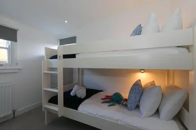 a white bunk bed with stuffed animals sitting on it at Harbour Moorings in St Ives