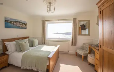 a bedroom with a large bed and a window at Mevagissey Bay Hotel in Mevagissey