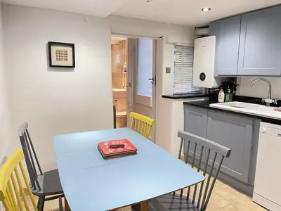 a kitchen with a table with a book on it at Sixpence Cottage, a few steps from the harbour! in St Ives