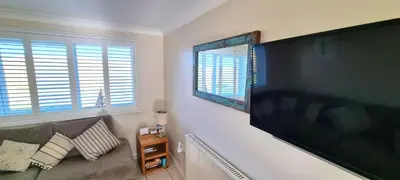a living room with a large flat screen tv on the wall at Ocean's Eddge, Perranporth in Perranporth