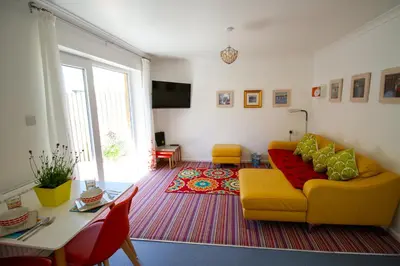 a living room with a yellow couch and a table at Krissie's in Marazion