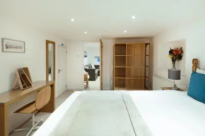 a bedroom with a large bed and a desk at Oasis Apartment in Falmouth