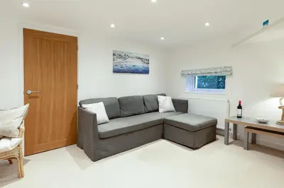 a living room with a couch and a table at Oasis Apartment in Falmouth