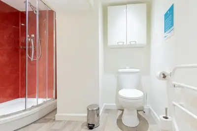 a bathroom with a toilet and a shower at Oasis Apartment in Falmouth