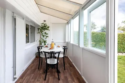 a small dining room with a table and windows at Oasis Apartment in Falmouth