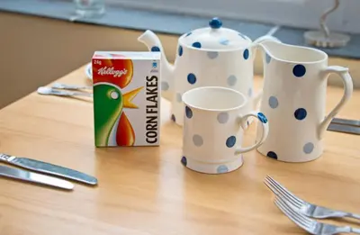 a table with two cups and a box of milk at Down Ende House Accommodation in Looe