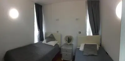 a small bedroom with a bed and a mirror at Down Ende House Accommodation in Looe