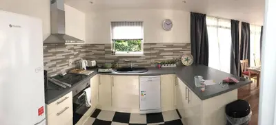 a kitchen with a black and white counter top at Down Ende House Accommodation in Looe