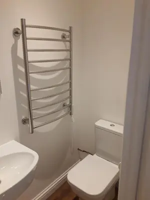 a white bathroom with a toilet and a sink at The Mandalay Guest House in Mevagissey
