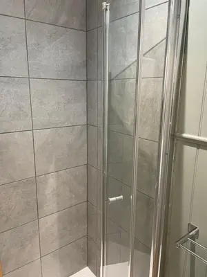 a shower with a glass door in a bathroom at The Mandalay Guest House in Mevagissey