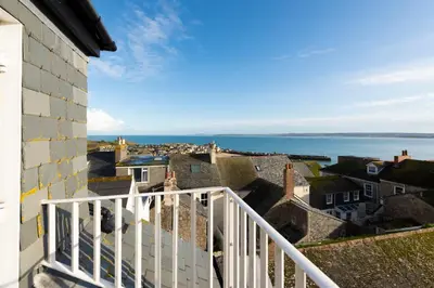 a view of the ocean from the balcony of a house at Waves Apartment, St Ives in St Ives