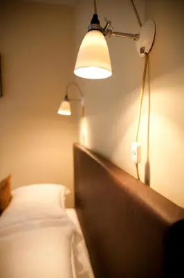 a bedroom with a bed with a lamp and a headboard at Spring Cottage B&B in Probus