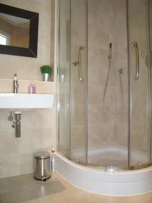 a shower with a glass door next to a sink at The Beach House & Porth Sands Apartments in Newquay