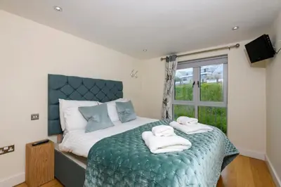 a bedroom with a large bed with towels on it at The Beach House & Porth Sands Apartments in Newquay