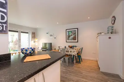 a kitchen and dining room with a dining table at The Beach House & Porth Sands Apartments in Newquay