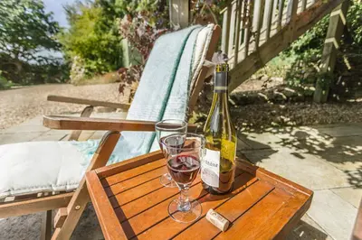 a bottle of wine and two glasses on a table at Pear Tree Barn - Amazing Country views - Pet friendly - Balcony in Newquay