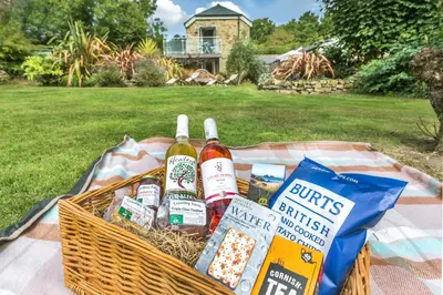 a basket of beer and food on a table at Pear Tree Barn - Amazing Country views - Pet friendly - Balcony in Newquay